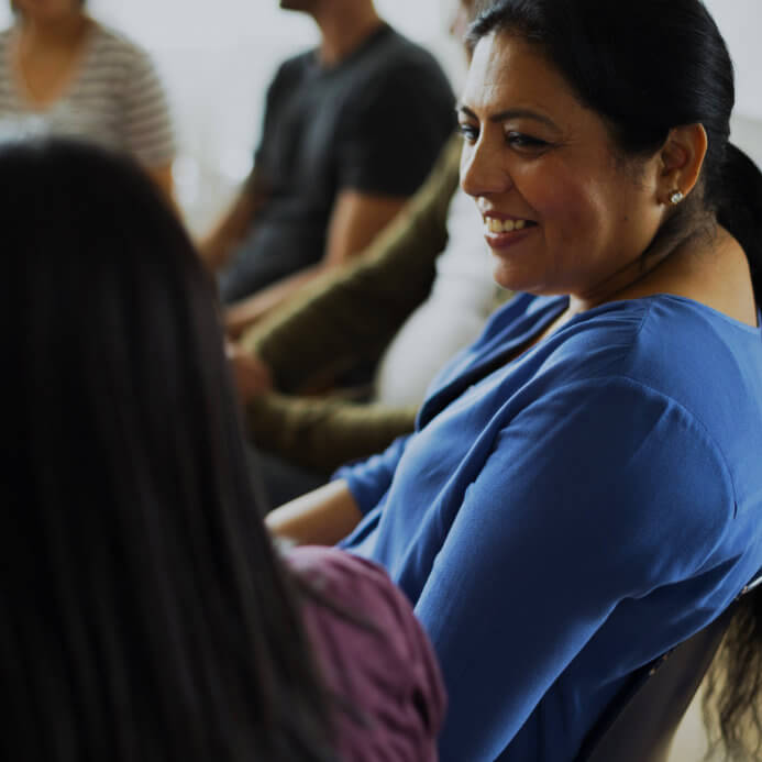 smiling woman looking at another woman