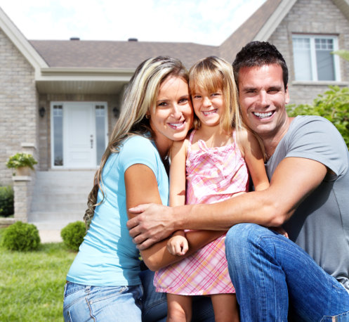 Happy family in front of house