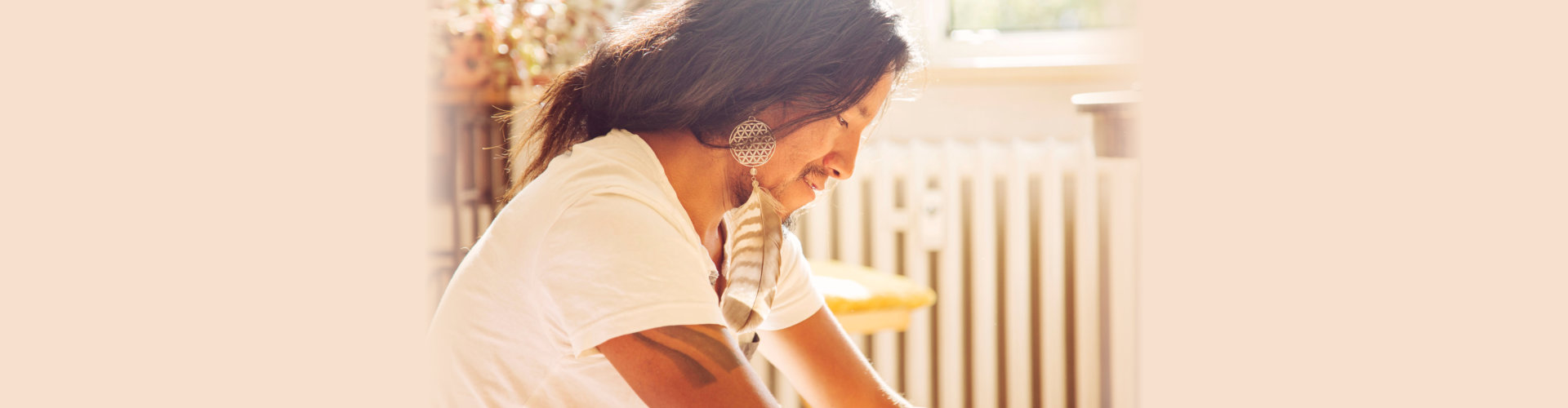 Portrait of young latino man sitting in the bright room